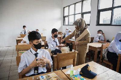 Guru memberikan cairan hand sanitizer pada siswa saat mengikuti Pembelajaran Tatap Muka Terbatas di SMPN 1 Depok, 4 Oktober 2021. TEMPO/M Taufan Rengganis