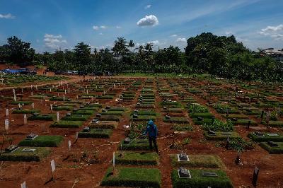 Petugas menyiram area pemakaman jenazah Covid-19 di TPU Pondok Ranggon, Jakarta, 2 Desember 2020. Tempo/Hilman Fathurrahman W