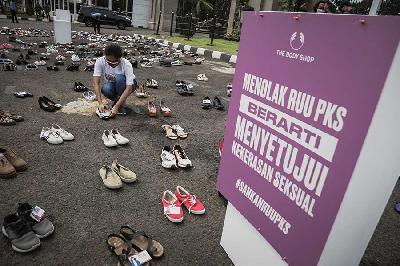 Aktivis saat meletakkan sepatu dalam aksi diam 500 langkah awal sahkan RUU PKS di depan Gedung DPR RI, Jakarta, 25 November 2020. TEMPO/M Taufan Rengganis