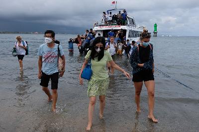 Sejumlah wisatawan mancanegara menggunakan masker turun dari kapal cepat di Pulau Nusa Penida, Sanur, Denpasar, Bali, 17 Oktober 2021. ANTARA/Nyoman Hendra Wibowo