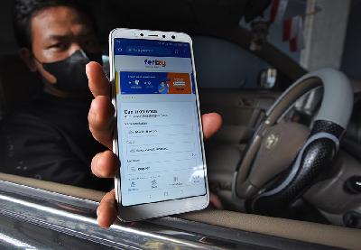 Warga memperlihatkan aplikasi permohonan tiket untuk penyeberangan di Pelabuhan Merak pada telepon pintarnya di Cilegon, Banten, 30 November 2021. ANTARA/Asep Fathulrahman