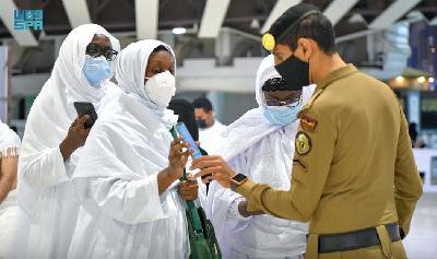 Petugas keamanan memeriksa dokumen vaksinasi di Mekah, Arab Saudi, 17 Oktober 2021. Saudi Press Agency/REUTERS