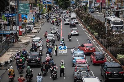Petugas Satuan Lalu Lintas Polres Metro Depok mengarahkan mobil saat uji coba sistem ganjil genap di Jalan Margonda Raya, Depok, 5 Desember 2021. TEMPO/M Taufan Rengganis