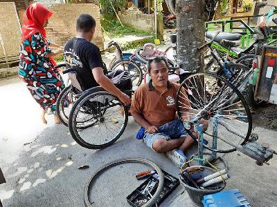 Teknisi Bengkel Kursi Roda "Maju Mapan" yang merupakan difabel mereparasi kursi roda di Kecamatan Bambanglipura, Kabupaten Bantul, 7 Desember 2021. TEMPO/Pito Agustin Rudiana