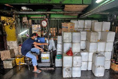 Pekerja mengisi minyak ke dalam jirigen di kawasan Cipete, Jakarta, 29 November 2021.  Tempo/Tony Hartawan
