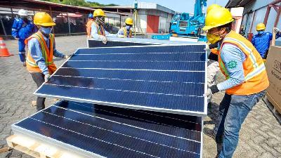 Pekerja melakukan pemasangan panel surya di pabrik Coca-Cola Amatil Indonesia, Cibitung, Bekasi, Jawa Barat, Desember 2020. TEMPO/Tony Hartawan