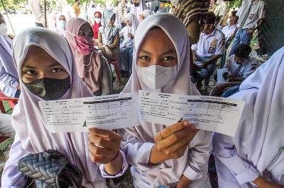 Pelajar SMP menunjukkan kartu antrean untuk mengikuti vaksinasi COVID-19  di Lhokseumawe, Aceh, 2 November 2021. ANTARA/Rahmad