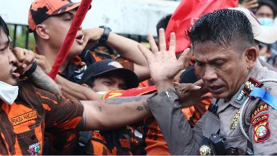 Members of the Pancasila Youth organization beating a member of the police, AKBP Karosekali during a protest in front of the Indonesian Parliament Building, Senayan, Jakarta, November 25.
TEMPO/Ridho Fadilla
