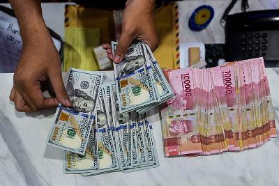 Petugas menghitung lembaran Dolar Amerika dan Rupiah di Jakarta, 6 Desember 2021. TEMPO/Tony Hartawan