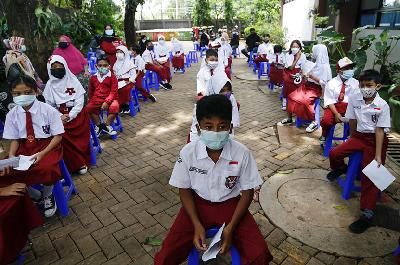 Siswa antre mendapatkan vaksin Covid-19 untuk anak-anak usia 6-11 tahun di  Jakarta, 14 Desember 2021. REUTERS/Ajeng Dinar Ulfiana