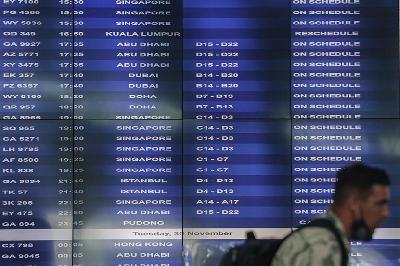 Warga Negara Asing (WNA) berjalan dekat papan informasi penerbangan di Terminal 3 Bandara Internasional Soekarno-Hatta, Tangerang, Banten, 29 November 2021. ANTARA/Fauzan