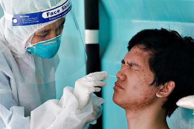 Petugas medis mengambil sampel dengan tes usap Covid-19 di Jakarta, 16 Desember 2021. REUTERS/Ajeng Dinar Ulfiana