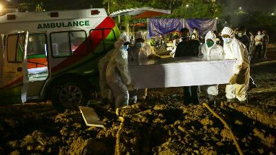 Prosesi pemakaman jenazah Covid-19 di TPU Rorotan, Jakarta Utara, Selasa, 6 Juli 2021. TEMPO/Hilman Fathurrahman W
