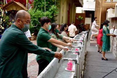 Sejumlah jemaat mencuci tangan dan mengenakan masker sebelum mengikuti misa malam Natal di Katedral Ambon, Maluku, 24 Desember 2021. ANTARA/FB Anggoro