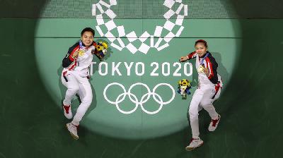 Apriyani Rahayu (kiri) dan Greysia Polii merayakan kegembiraan usai meraih medali emas di Olimpiade Tokyo, 2 Agustus 2021/Pool via REUTERS/Lintao Zhang