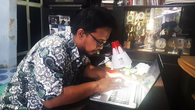 Muhammad Baihaqi, mengoperasikan laptop di rumahnya di Kelurahan Kraton Lor Kota Pekalongan pada Kamis, 23 Desember 2021/TEMPO/  Jamal A. Nashr