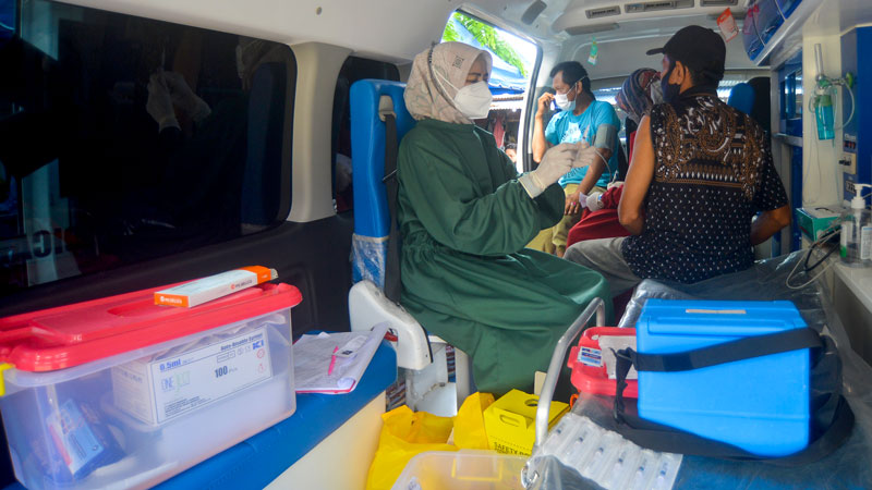 Tenaga kesehatan bersiap menyuntikkan vaksin Covid-19 kepada warga di dalam mobil vaksinasi keliling di Pasar Ulakkarang, Padang, Sumatera Barat, 1 November 2021. ANTARA/Iggoy el Fitra