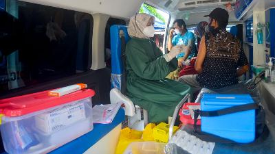 Tenaga kesehatan bersiap menyuntikkan vaksin Covid-19 kepada warga di dalam mobil vaksinasi keliling di Pasar Ulakkarang, Padang, Sumatera Barat, 1 November 2021. ANTARA/Iggoy el Fitra