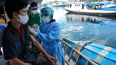 Indonesian Navy medical team injects the Covid-19 vaccine to a resident on a fishing boat at Paotere Port, Makassar, South Sulawesi, in June.
ANTARA PHOTOS/Abriawan Abhe
