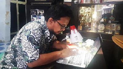 Muhammad Baihaqi typing on his laptop at his home in the Kraton Lor village, Pekalongan, Central Java, December 23.
TEMPO/Jamal A. Nashr
