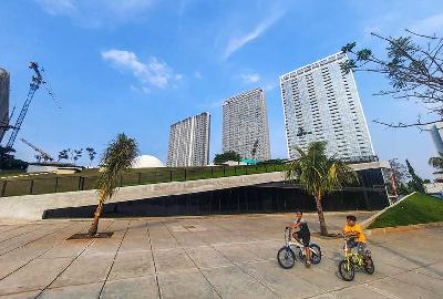 Anak-anak bermain di dekat proyek pembangunan revitalisasi Taman Ismail Marzuki di Cikini, Jakarta, 23 Agustus 2021. TEMPO/Hilman Fathurrahman W