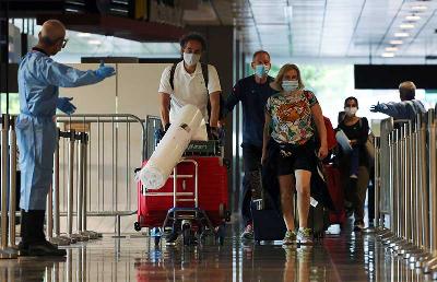 Penumpang dari Amsterdam tiba di Bandara Udara Changi pada pemberlakuan skema perjalanan bebas karantina Vaccinated Travel Lane (VTL) di Singapura, 20 Oktober 2021. REUTERS/Edgar Su