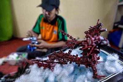 Pengerajin membuat miniatur robot dari limbah korek api gas di Kantor Sudin Lingkungan Hidup Jakarta Timur, 30 September 2021. Tempo/Tony Hartawan