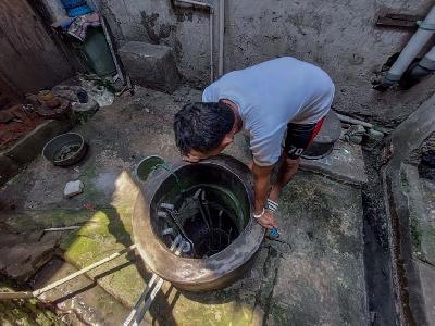 Warga memeriksa pasokan air di sumur di Jalan Lodan Raya, Gang Madrasah, Kampung Bandan, Jakarta Utara, 4 Januari 2022. TEMPO / Hilman Fathurrahman W