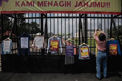 Massa dari Jaringan Pembela Hak Perempuan Korban Kekerasan Seksual memasang instalasi baju korban kekerasan seksual saat melakukan aksi unjuk rasa di depan Gedung DPR, Jakarta, 22 Desember 2021. TEMPO/M Taufan Rengganis
