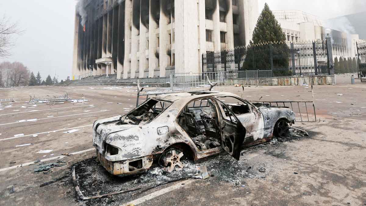 Sebuah mobil dan gedung kantor walikota yang dibakar selama protes di Almaty, Kazakhstan 6 Januari 2022. REUTERS/Pavel Mikheyev 