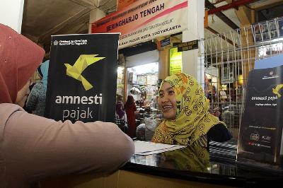 Petugas memberikan penjelasan program amnesti pajak kepada pedagang di Pasar Beringharjo, Yogyakarta, 29 November 2016. Dok. TEMPO/Pius Erlangga
