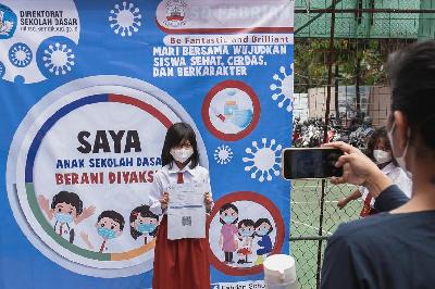 Siswa berfoto saat pelaksanaan vaksinasi Covid-19 di SD Fabrian School, Limo, Depok, Jawa Barat, 10 Januari 2022. TEMPO/M Taufan Rengganis