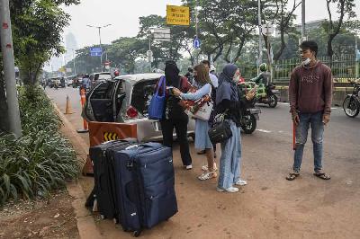Pekerja Migran Indonesia (PMI) menunggu kendaraan usai menjalani karantina di kompleks Rumah Susun (Rusun) Pasar Rumput, Jakarta, 5 Januari 2022. ANTARA/Galih Pradipta