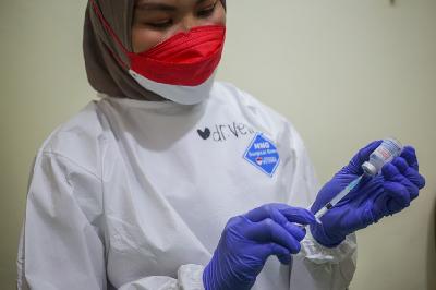 Vaksinator memasukkan dosis vaksin Moderna ke dalam jarum suntik sebagai vaksin dosis ketiga atau booster di Rumah Sakit Umum Daerah (RSUD) Matraman, Jakarta,  6 Agustus 2021. TEMPO / Hilman Fathurrahman W