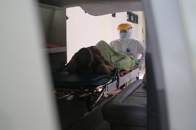 Tenaga kesehatan memasukkan pasien ke dalam mobil ambulans untuk dipindahkan ke ruang perawatan khusus pasien Covid-19 di RSUD Chasbullah Abdulmajid, Kota Bekasi, Jawa Barat, 4 Februari 2022. TEMPO/Hilman Fathurrahman W