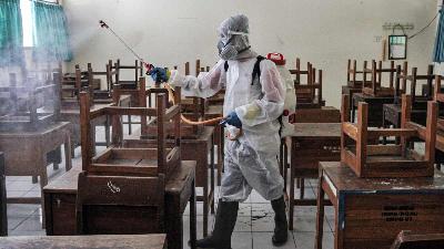 Petugas PMI menyemprotkan cairan disinfektan akibat meningkatnya kasus penyebaran Covid-19 dari sekolah di Jakarta, 4 Februari 2022. TEMPO/Muhammad Hidayat