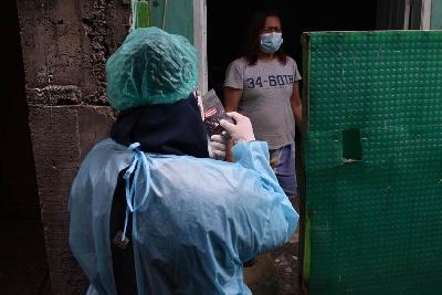 Petugas Puskesmas Jajaway menjelaskan cara penggunaan obat saat kunjungan pemberian obat pasien Covid-19 yang menjalani isolasi mandiri di kawasan Antapani, Bandung, Jawa Barat, 2021. TEMPO/Prima mulia