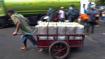 A coolie pulls a cartful of cooking oil in jerry cans to be re-sold at the Kramat Jati Market in Jakarta, Thursday, February 3. 2022. Tempo/Tony Hartawan