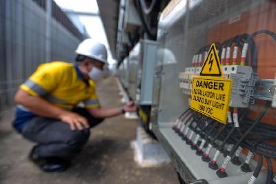 Pekerja melakukan pengecekan arus listrik yang dihasilkan oleh panel surya di pabrik Coca-Cola Amatil Indonesia, Cibitung, Bekasi, Jawa Barat, 2020. Tempo/Tony Hartawan