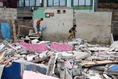 Sejumlah anak bermain direruntuhan puing bangunan akibat penggusuran di Kampung Muka, Ancol, Jakarta, 20 Juli 2020. Tempo/Hilman Fathurrahman W