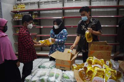 Petugas membagikan minyak goreng 2 liter sesuai nomor antrean yang dibeli secara terbatas di pasar swalayan Borma di Bandung, Jawa Barat, 18 Februari 2022. TEMPO/Prima Mulia