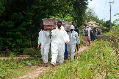 Petugas pemakaman memikul peti jenazah warga yang meninggal karena positif Covid-19 di pemakaman khusus Covid-19 di Bandung, Jawa Barat, 23 Februari 2022. TEMPO/Prima Mulia