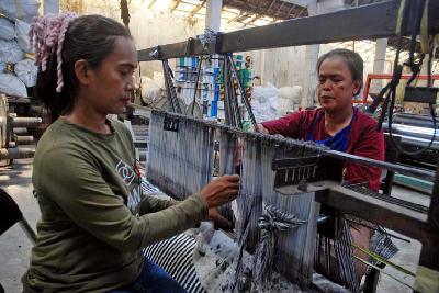 Pekerja membuat pola benang secara manual di sebuah pabrik kain skala kecil menengah di Desa Rancajigang, Kecamatan Majalaya, Kabupaten Bandung, Jawa Barat.  TEMPO/Prima Mulia
