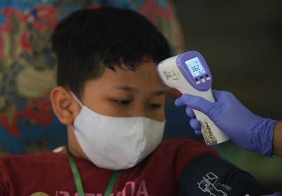 Seorang anak saat akan mengikuti vaksin Covid 19 di RPTRA Gondangdia, Jakarta, 13 Januari 2022. TEMPO/Subekti