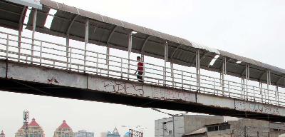 Pejalan kaki melintasi jembatan penyebrangan orang (JPO) di Jalan Letjen Suprapto, Jakarta, 30 November 2021. TEMPO/Dwi Nur A. Y