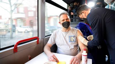 Menteri Kesehatan Jerman Karl Lauterbach (kanan) memberikan vaksinasi kepada penumpang bus wisata di Berlin, Jerman, 10 Maret 2022. Michele Tantussi/Pool via REUTERS