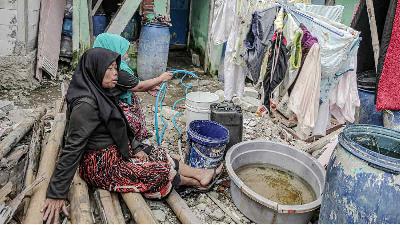 Seorang warga mengumpulkan air bersih menggunakan ember di kawasan Muara Angke, Jakarta, 1 Maret 2022/TEMPO/Muhammad Hidayat