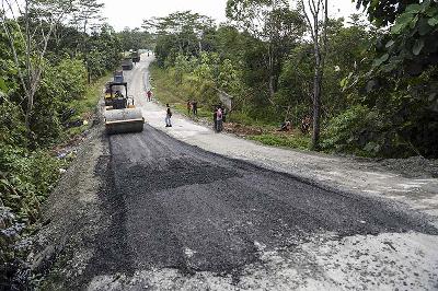 Pekerja mengoperasikan alat berat memperbaiki Jalan Semboja-Sepaku di Samboja, Kutai Kartanegara, Kalimantan Timur, 13 Maret 2022. ANTARA/Hafidz Mubarak A