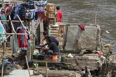 Warga mencuci piring di bantaran Kali Ciliwung, Bukit Duri, Jakarta, 9 September 2020. TEMPO/Subekti