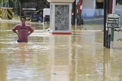 Warga melintas saat banjir menggenangi kawasaan Damai, Balikpapan, Kalimantan Timur, 16 Maret 2022. ANTARA/Hafidz Mubarak A